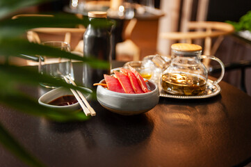 Tuna sashimi on a plate on a table in a sushi bar.
