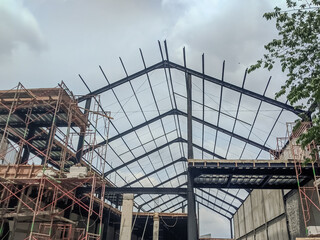 Steel frame structure, steel frame workshop is under construction against a blue sky, blue steel in steel installation construction
