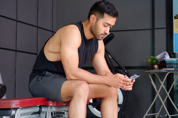 Obraz premium Young man exercising in a fitness gym. Health and fitness.