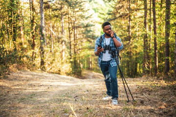 Worried hiker got lost and he is using a phone to find right direction while hiking in the nature.	