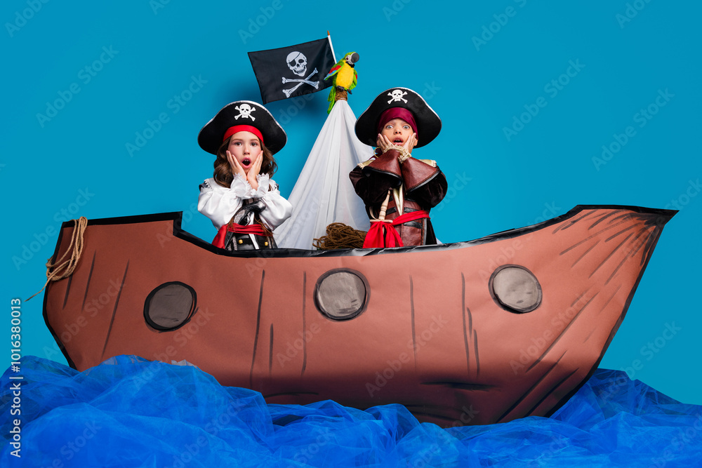 Poster Full body portrait of two impressed little kids halloween pirate costume sail boat isolated on blue color background