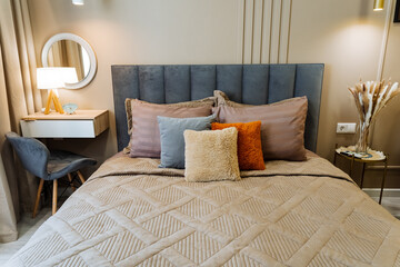 A cozy bedroom with a comfortable bed, functional desk for work, stylish chair for relaxation, and an elegant mirror that adds sophistication and serves personal grooming needs