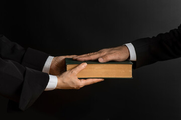 Hand on the Bible in court or the oath on the constitution book during the inauguration in parliament. Oath of Office.