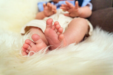 Close-up of a newborn baby's feet lying on cosy faux fur