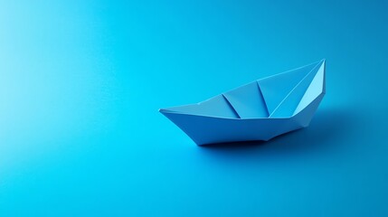 Obraz premium A blue paper boat on a blue background.