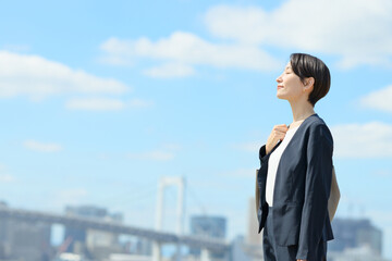 青空の中に立つビジネスウーマン