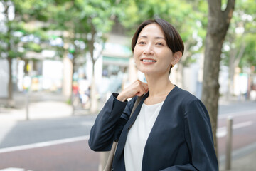 スーツ姿で歩く女性