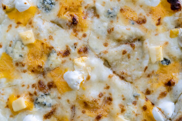 Close-up of sliced pizza with melted cheese triangles on a textured white background. Flat lay food photography