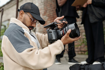 Man operating a professional video camera outdoors capturing detailed footage of surroundings...