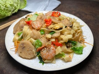 Spicy fried noodle with shrimp, chicken meat ball and vegetables. Thai style food.