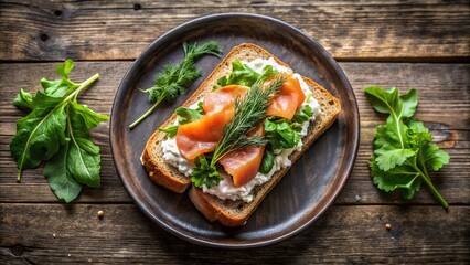Aerial shot of salmon and cream cheese sandwich with fresh greens on a rustic plate