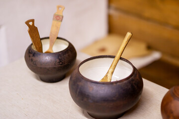 There are two bowls containing wooden spoons placed on a table