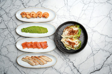 Lettuce salad with shrimps, avocado, salmon and chicken breast