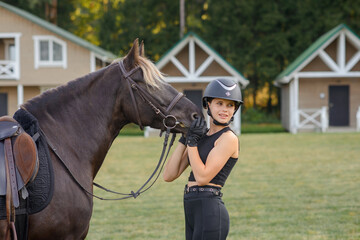 beautiful girl with horse walking in park in summer. equestrian sport