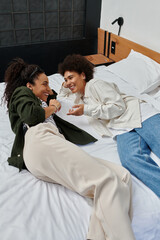 A happy couple relaxes and shares laughter in their cozy hotel room, enjoying each other's company.