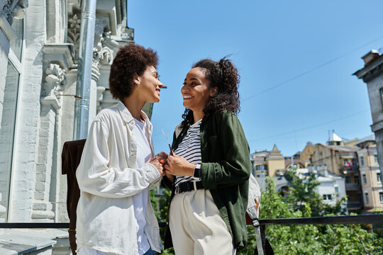 A happy couple shares a joyous moment on their hostel balcony, enjoying their travel adventure together.