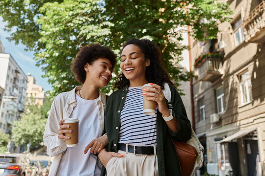 A happy couple laughs together, sipping coffee, while exploring their vibrant city surroundings.