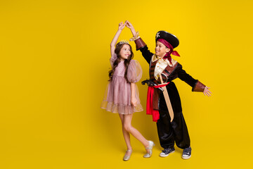 Full body portrait of two small kids halloween pirate princess costume dance empty space isolated on yellow color background