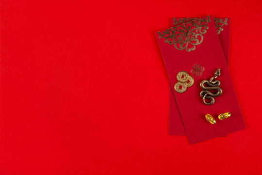 Chinese asia New Year golden red background. New zodiac year Snake 2025 greeting card. Red flat lay background with holiday fans, wishes envelopes, snake statue in traditional chinese style