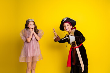 Photo of two kids halloween princess pirate costume horror scared isolated on yellow color background