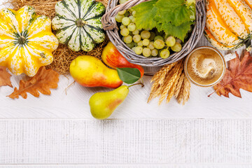 Autumn-themed food arrangement with coffee, pumpkins, grapes, and autumn leaves