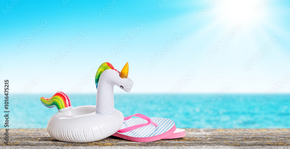 Poster lip flops and a floating flamingo placed on a table with a sunny sea