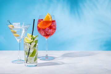 A variety of cocktails arranged on a table against a light blue background