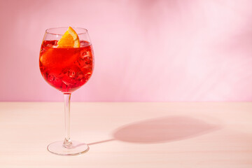 A cocktail arranged on a table against a light pink background