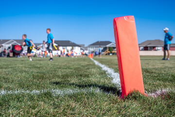 Selective focus on a pylon with a defocused flag football game in the background  © Lost_in_the_Midwest