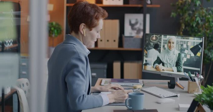 Two businesswomen colleagues talking at virtual meeting making online video call sharing business ideas in office. Communication and professional cooperation concept.