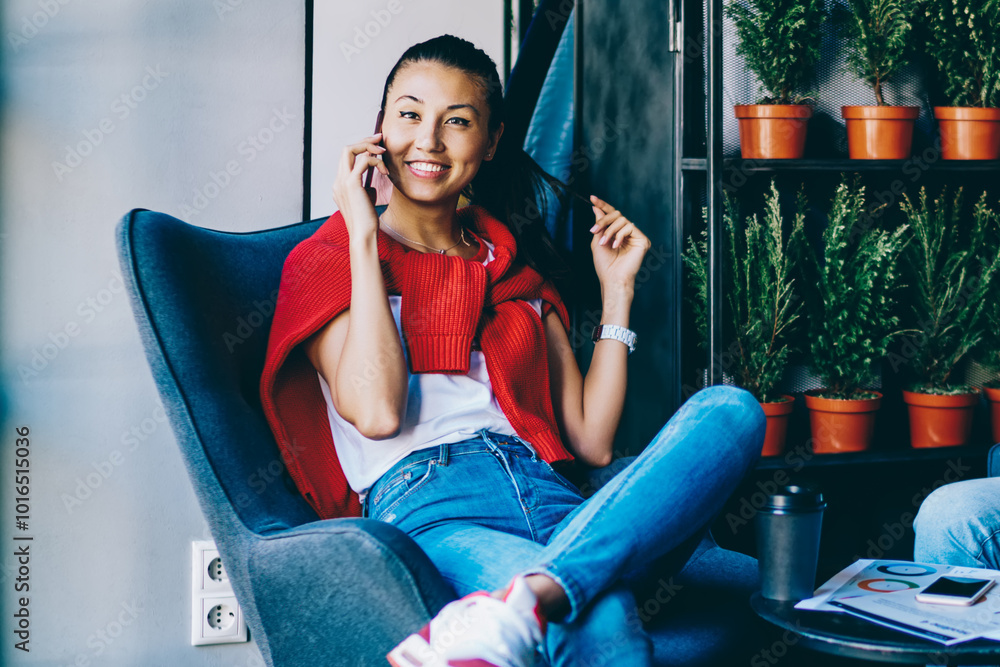 Poster portrait of cheerful hipster girl resting in loft cafeteria and using wifi connection for making sma