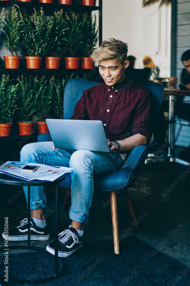 Poster portrait of cheerful hipster girl resting in loft cafeteria and using wifi connection for making sma