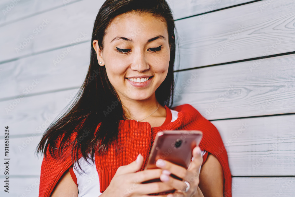 Poster happy cheerful chinese woman updating profile in social network downloading media file via applicati