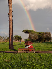 Roma, innamorati sotto l'ombrello guardano l'arcobaleno. 