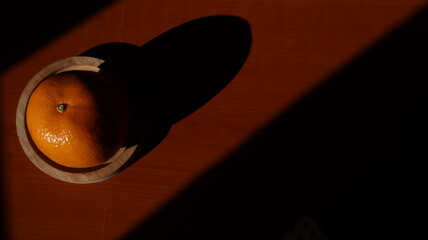 oranges fruit composition on wooden kitchen table, illuminated by the sun light.