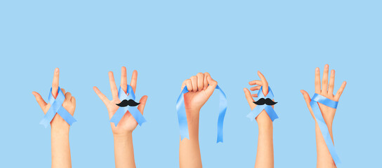 Men's health and Prostate cancer awareness campaign in November. Group of men hands holding blue ribbon awareness  with mustache to support and fight for health.  Movember campaign banner.