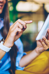 Obraz premium Cropped image of female hands typing text message via digital gadget connected to 4g wireless internet indoors, woman searching information for future trips on content websites via touch pad