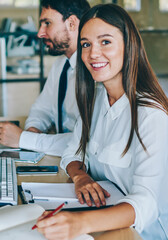 Fototapeta premium Portrait of successful female coworker looking at camera during break of searching information about finance news in world via modern computer with blank screen for your internet advertising