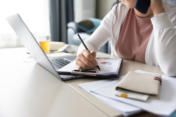 창가가 있는 거실에서 재택근무중인 여성이 스마트폰으로 통화중 