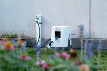 Retractable hose reel attached to the garden faucet.