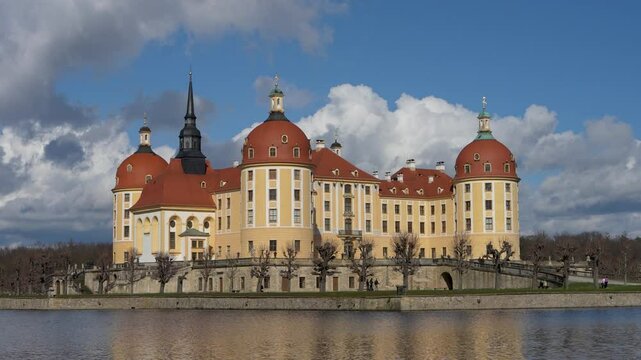 Beautiful famous Moritzburg Castle, castle above lake. Big clouds in sky. Castle is reflected in water.  German architecture, Germany