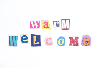 Welcome symbol. Concept words Warm Welcome isolated on clean white background in fun cut out newspaper style typescript. 