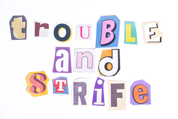 Phrase Trouble and Strife spelled in cut out newspaper style typography isolated on white background.