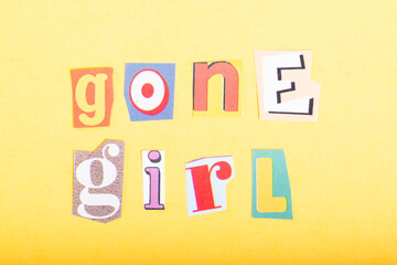 Phrase Gone Girl spelled in cut out newspaper style typography, isolated on yellow background.