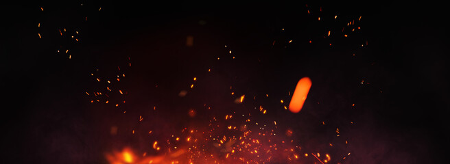 Fire embers particles over black panorama background. Fire burn sparks background. Abstract dark...