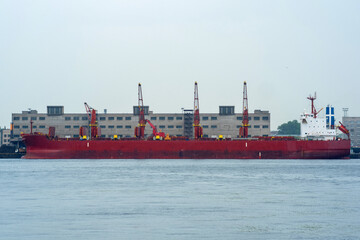 bulk carrier ship in a cargo port on a cloudy day