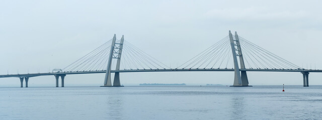 Obraz premium distant bridge over foggy bay on rainy day