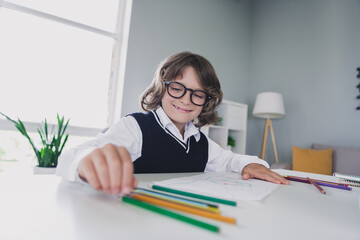 Portrait of diligent adorable schoolkid hold pencil drawing arts homework desktop house inside