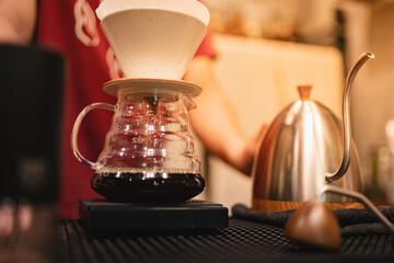 At the cozy cafes, the barista expertly brewed a hot drink, using a drip filter and paper to create the perfect cup, each beverage crafted with care and passion.