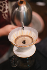 At the cozy cafes, the barista expertly brewed a hot drink, using a drip filter and paper to create the perfect cup, each beverage crafted with care and passion.